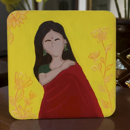Hand-painted wooden coaster of a woman in a red saree on a yellow floral background