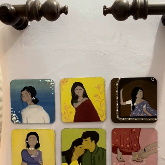 Set of six hand-painted wooden coasters depicting women in sarees and a couple